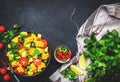 Vegan salad with sweet corn, avocado, jalapeno pepper, red tomatoes, fresh cilantro and olive oil and lime dressing. Black table Royalty Free Stock Photo