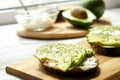 Vegan sandwich, rye bread toast, avocado slices, vegenaise sauce & raw arugula. Toasted sourdough, eggless mayonnaise, wooden tabl Royalty Free Stock Photo