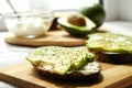 Vegan sandwich, rye bread toast, avocado slices, vegenaise sauce & raw arugula. Toasted sourdough, eggless mayonnaise, wooden tabl Royalty Free Stock Photo