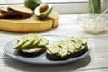 Vegan sandwich, rye bread toast, avocado slices, vegenaise sauce & raw arugula. Toasted sourdough, eggless mayonnaise, wooden tabl Royalty Free Stock Photo