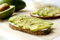 Vegan sandwich, rye bread toast, avocado slices, vegenaise sauce & raw arugula. Toasted sourdough, eggless mayonnaise, wooden tabl Royalty Free Stock Photo