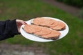 Vegan sausage on slice of bread, on plate in hand. Close-up view Royalty Free Stock Photo