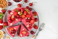 Vegan strawberry and cherry cheesecake with fresh berries and nuts and two slices of cake in a plate. top view Royalty Free Stock Photo