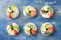 Vegan sushi donuts set with pickled ginger, avocado, cucumber, chives, nori and sesame on blue background. Sushi-food hybrid trend