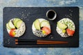 Vegan sushi donuts set with pickled ginger, avocado, cucumber, chives, nori and sesame on blue background. Sushi-food hybrid trend