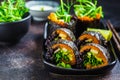 Vegan sushi rolls with black rice, avocado and sweet potato on black dish. Vegan food concept Royalty Free Stock Photo