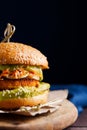 Vegan sweet potato chickpea burgers with avocado guacamole sauce and carrot slaw on dark blue background