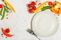 Vegan table setting. Assorted of ripe fresh vegetables, empty plate, cutlery, spices Royalty Free Stock Photo