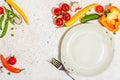 Vegan table setting. Assorted of ripe fresh vegetables, empty plate, cutlery, spices Royalty Free Stock Photo