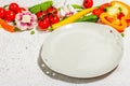 Vegan table setting. Assorted of ripe fresh vegetables, empty plate, cutlery, spices Royalty Free Stock Photo