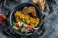 Vegan tofu scramble with vegetables, salad and toasted bread in plate over grey background. Healthy breakfast food, clean eating,