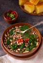 Vegan US southern black-eye peas and collard greens with corn bread in the background