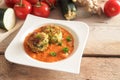 Vegan and vegetarian vegetable balls from zucchini and potato in tomato sauce with parsley garnish in a white plate, ingredients Royalty Free Stock Photo