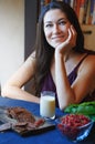 Vegan woman sitting at the table with healthy food