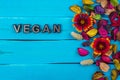 Vegan word on blue wood with flower Royalty Free Stock Photo