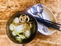 Vege Ball soup in a brown bowl on wooden table. Top view.