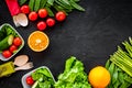 Vegearian lunch. Vegetables tomato, cucumber, asparagus, salad, orange on black background top view copyspace