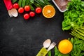 Vegearian lunch. Vegetables tomato, cucumber, asparagus, salad, orange on black background top view copyspace