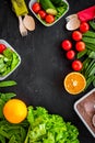 Vegearian lunch. Vegetables tomato, cucumber, asparagus, salad, orange on black background top view copyspace