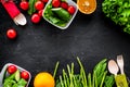 Vegearian lunch. Vegetables tomato, cucumber, asparagus, salad, orange on black background top view copyspace