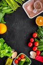 Vegearian lunch. Vegetables tomato, cucumber, asparagus, salad, orange on black background top view copyspace