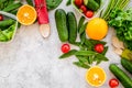 Vegearian lunch. Vegetables tomato, cucumber, asparagus, salad, orange on grey background top view copyspace