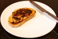 Vegemite and butter on sough dough toast with knife on Kitchen bench. An classic icon Australian spread.