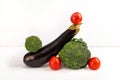 Vegetable art composition. Abstract balancing construction of eggplant, broccoli and tomatoes. Royalty Free Stock Photo