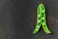 Vegetable backdrop vith copy space for your projects. Close up of fresh ripe green peas on black background Royalty Free Stock Photo