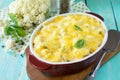 Vegetable casserole cauliflower meat and cheese on a wooden kitchen table, home kitchen