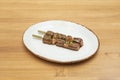 Vegetable chicken skewer, yakitori, with yakisoba sauce on a white plate with sesame seeds, poppy