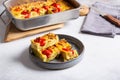 Vegetable clafoutis on gray plate on concrete background, savory pie with cabbage and whole cherry tomatoes. Vegetarian cuisine