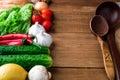 Vegetable composition on a wooden board includes: garlic, onion, green salad, bread, red pepper, tomatoes, cucumbers, lemon, Royalty Free Stock Photo