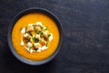 Vegetable cream pumpkin soup with carrot and crackers. Top view on a dark creative background. Healthy diet meal.