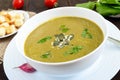 Vegetable cream soup with spinach and potatoes in a white bowl with garlic croutons on a dark wooden background. Royalty Free Stock Photo