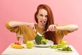 Vegetable diet. Sad dull woman holding broccoli on fork while making grimace Royalty Free Stock Photo