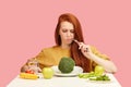 Vegetable diet. Sad dull woman holding broccoli on fork while making grimace Royalty Free Stock Photo