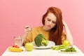 Vegetable diet. Sad dull woman holding broccoli on fork while making grimace Royalty Free Stock Photo