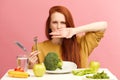 Vegetable diet. Sad dull woman holding broccoli on fork while making grimace Royalty Free Stock Photo