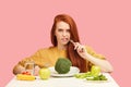 Vegetable diet. Sad dull woman holding broccoli on fork while making grimace Royalty Free Stock Photo