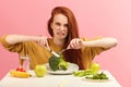 Vegetable diet. Sad dull woman holding broccoli on fork while making grimace Royalty Free Stock Photo