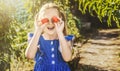 Vegetable garden. Cheerful smiling little girl with tomato harvest. child - little gardener with organic tomatoes