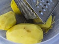 Vegetable grater and peeled potatoes ready to be shredded Royalty Free Stock Photo