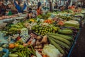 Vegetable market with traders and greens, salad, zucchini, pepper, limes on the counter of bazaar