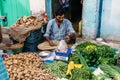 Vegetable merchant sell potato that weigh by digital scales in the morning market in Kolkata, India