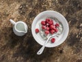 Vegetable milk oatmeal porridge with fresh raspberries on a wooden background, top view