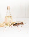 Vegetable oil in a bottle with seasonings and spices on a white wooden background. Royalty Free Stock Photo