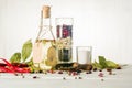 Vegetable oil in a bottle with seasonings and spices on a white wooden background. Royalty Free Stock Photo