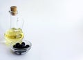 Vegetable oil in a glass bottle and black olives in a glass bowl Royalty Free Stock Photo