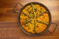 Vegetable paella rice with vegetables in paella pan, on wooden background